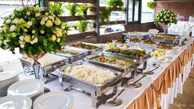 Rustic catered buffet spread with fresh flowers and chafing dishes