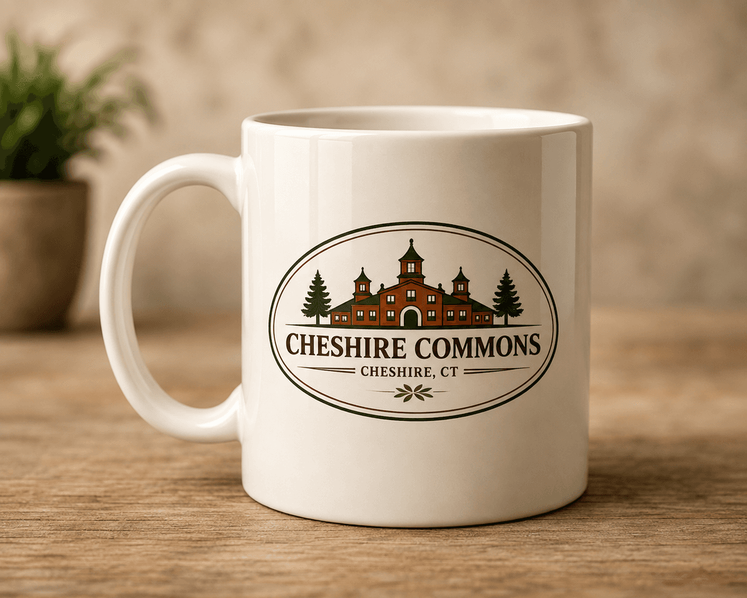 White ceramic mug printed with the Cheshire Commons building crest