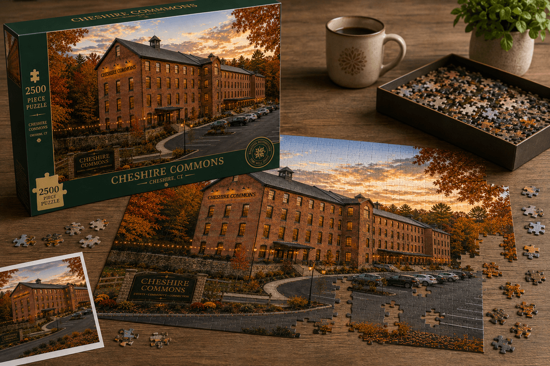 Box and assembled pieces of a 2,500-piece jigsaw puzzle of the Cheshire Commons building at sunset