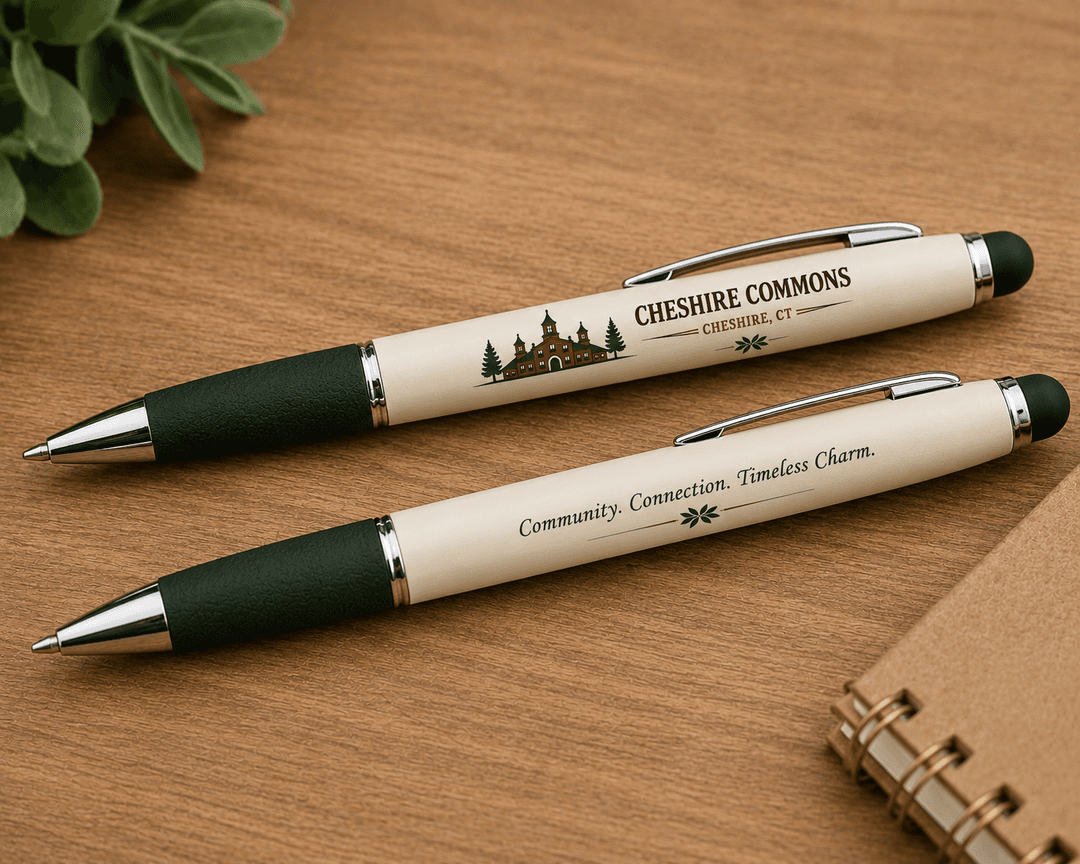 Two ivory ballpoint pens printed with the Cheshire Commons crest and mission statement