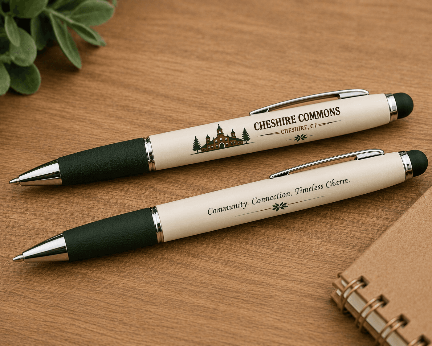 Two ivory ballpoint pens printed with the Cheshire Commons crest and mission statement