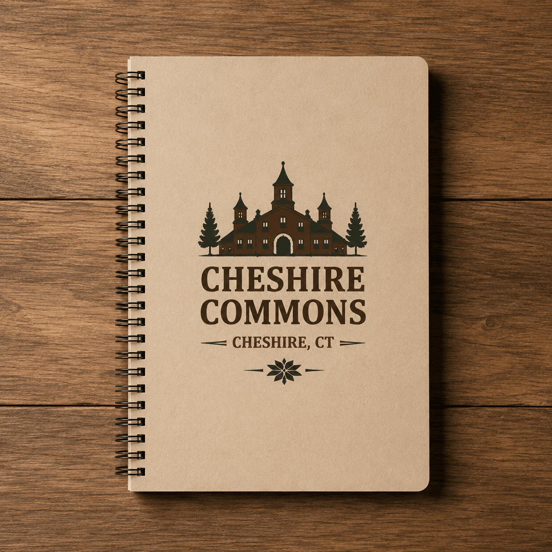 Kraft-colored spiral softcover notebook with the Cheshire Commons crest