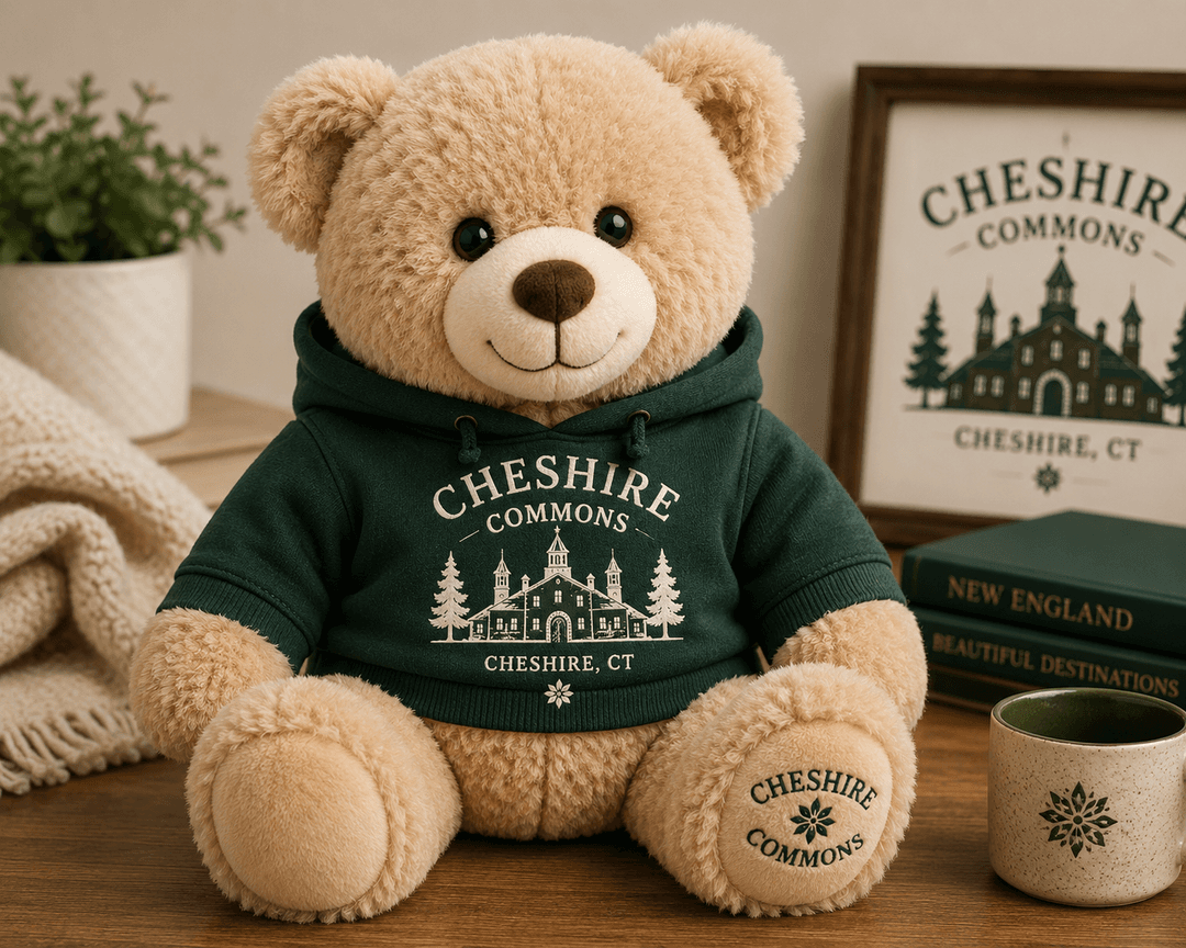 Plush teddy bear wearing a forest green Cheshire Commons hoodie